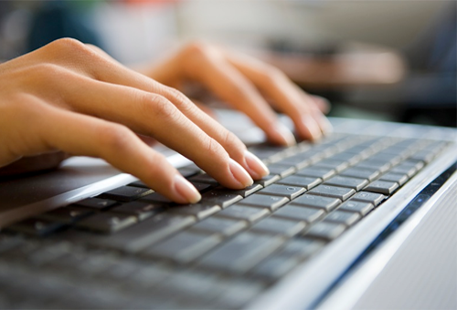 female hands typing on a laptop